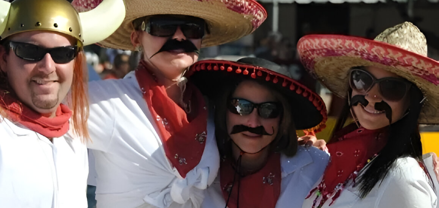 Two people in sombreros and ties posing for a picture.