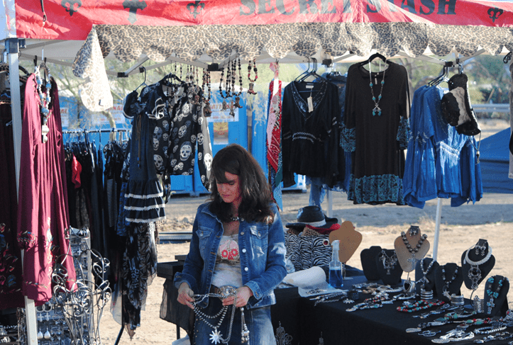 A woman standing next to a table with several items on it.