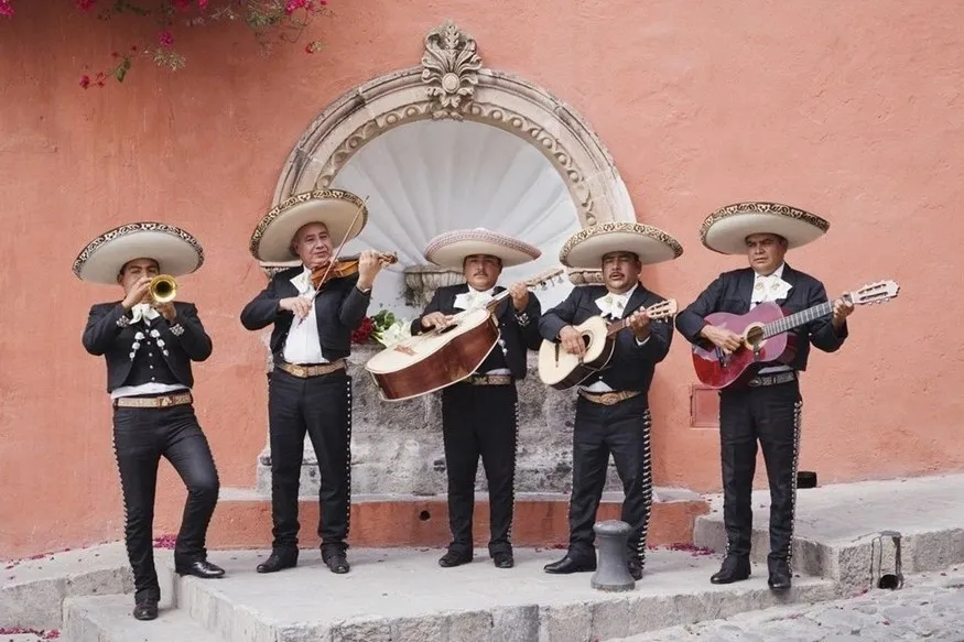 A group of men in black and white suits playing instruments.