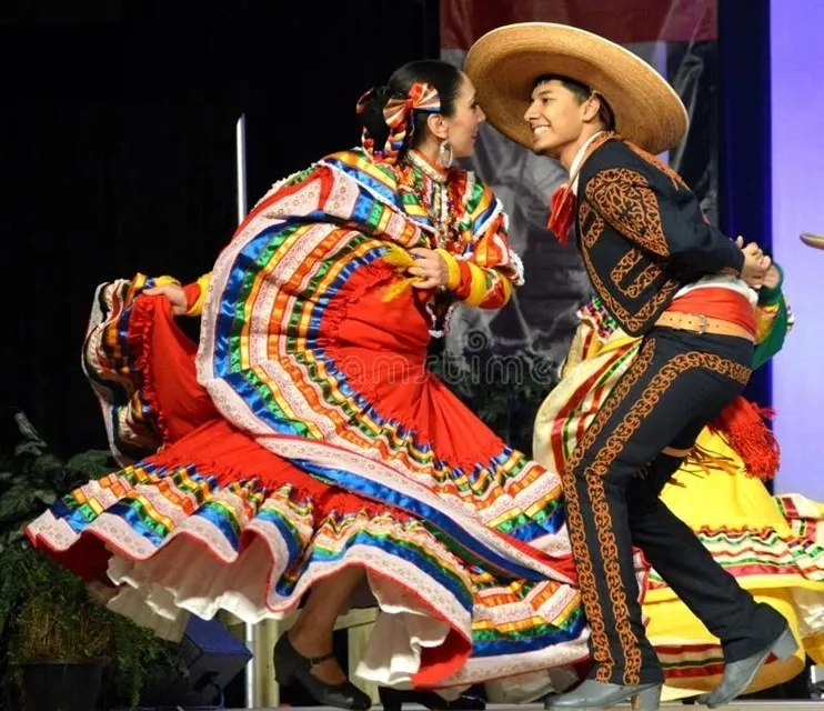 Two people in colorful costumes dancing on stage.