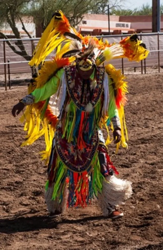 A person in costume standing on dirt ground.