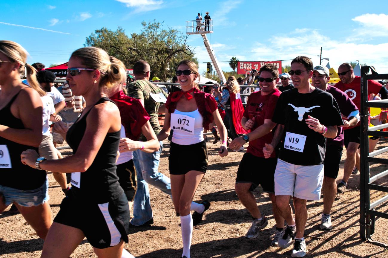 A group of people running in the dirt.