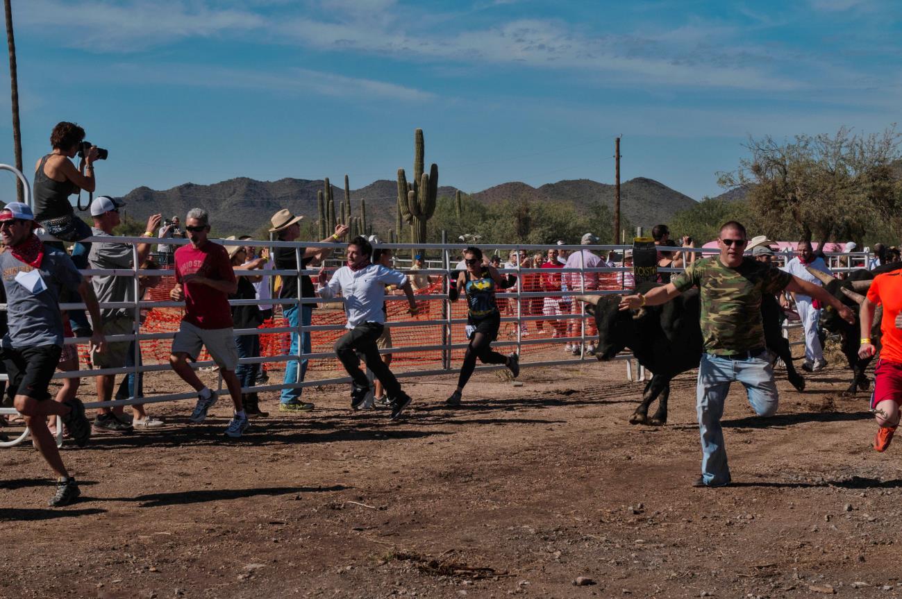 A group of people playing ball in the dirt.