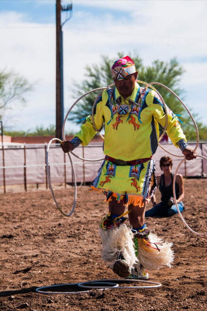 A man in yellow and black shirt holding a rope.