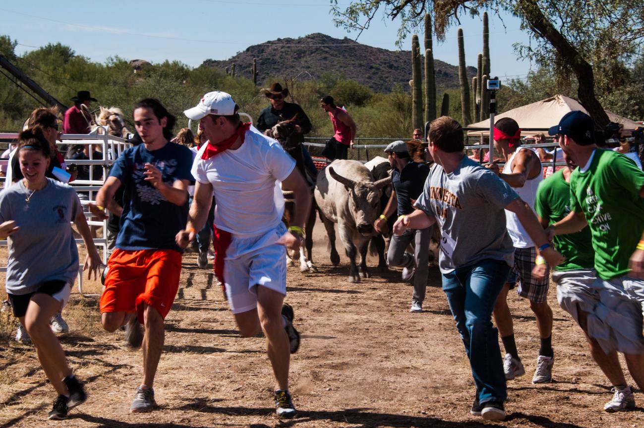 A group of people running in the dirt.