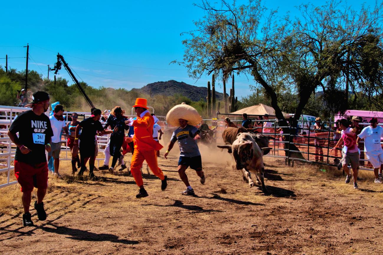 A group of people in the dirt with animals.