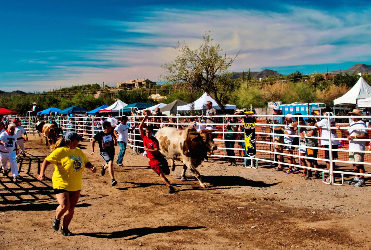 A group of people running around in the dirt.