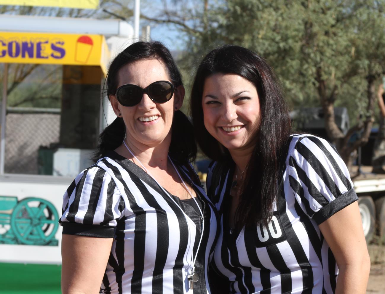 Two women in referee uniforms posing for a picture.