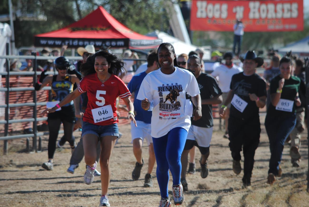 A group of people running in the dirt.