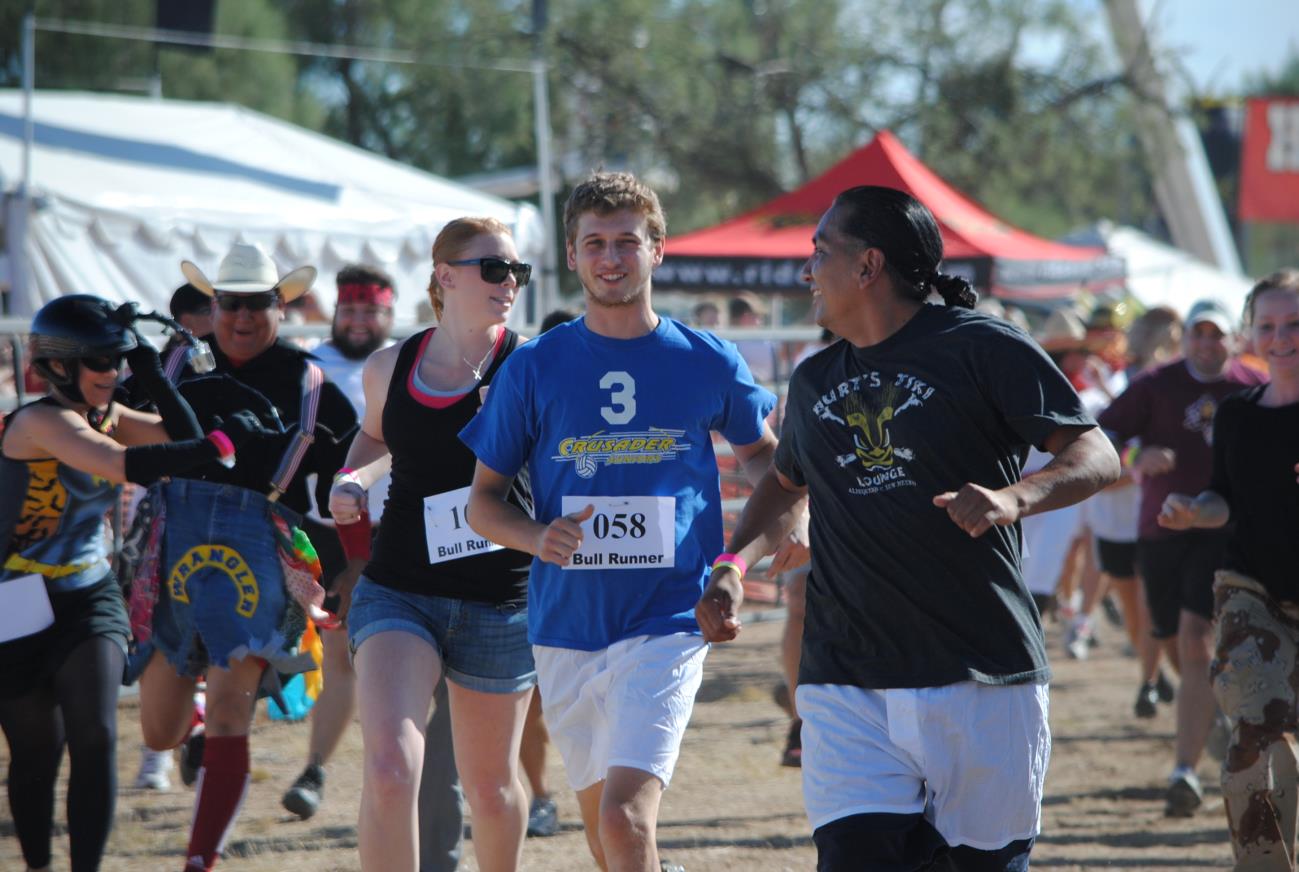 A group of people running in the dirt.