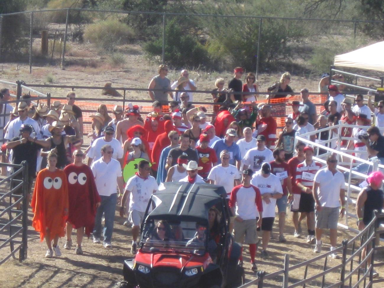 A crowd of people standing around an atv.