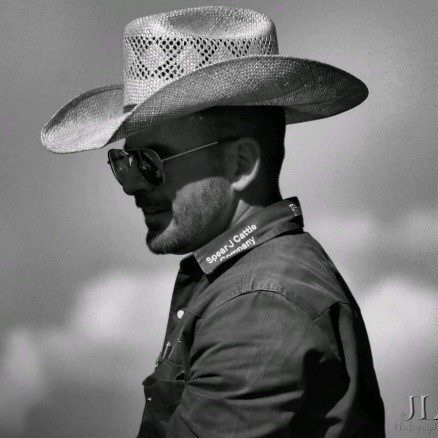 A man wearing a cowboy hat and sunglasses.