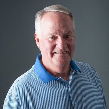 A man with grey hair and blue shirt