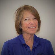 A woman with short hair wearing a blue shirt.